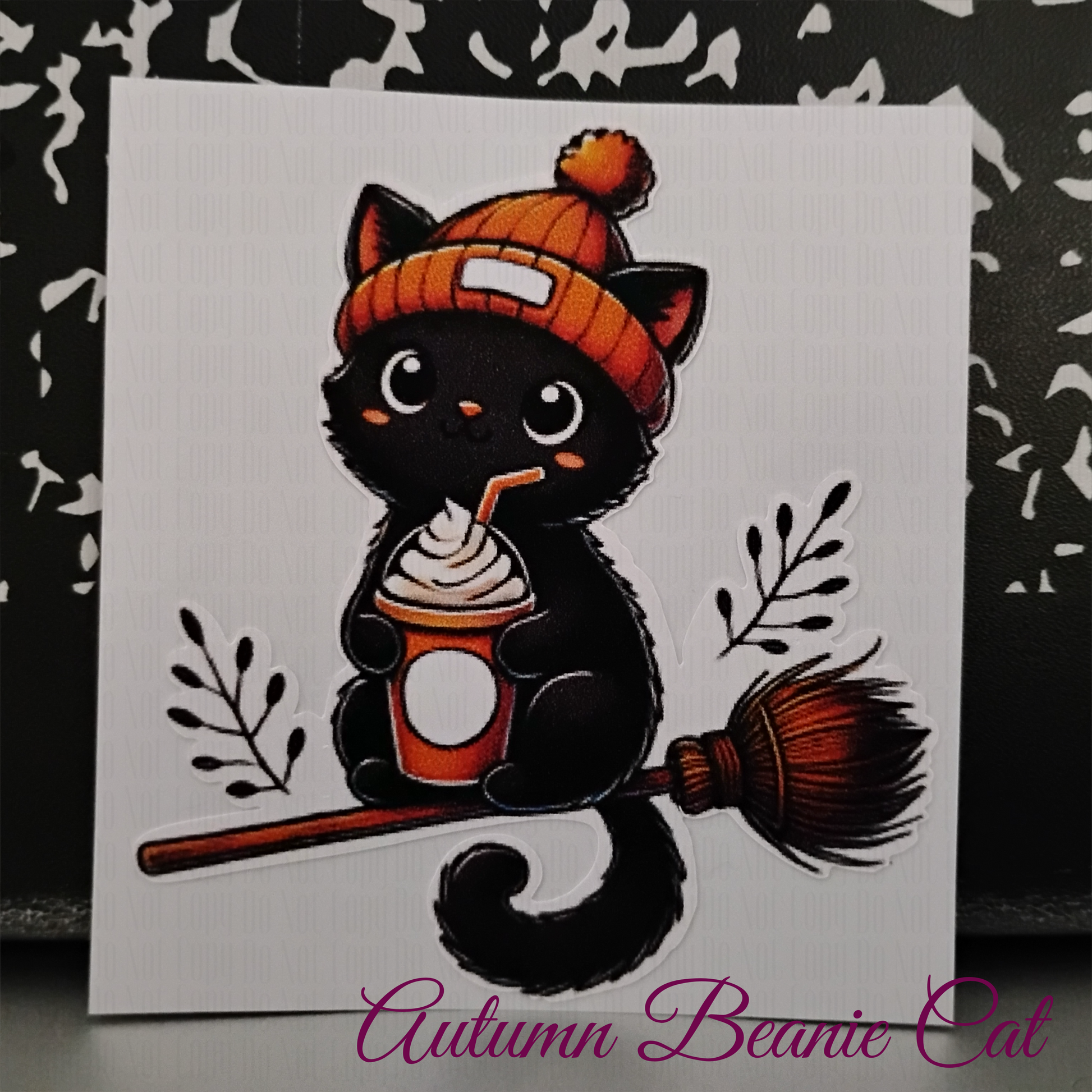 black cat in orange beanie holding fall latte - cozy halloween sticker