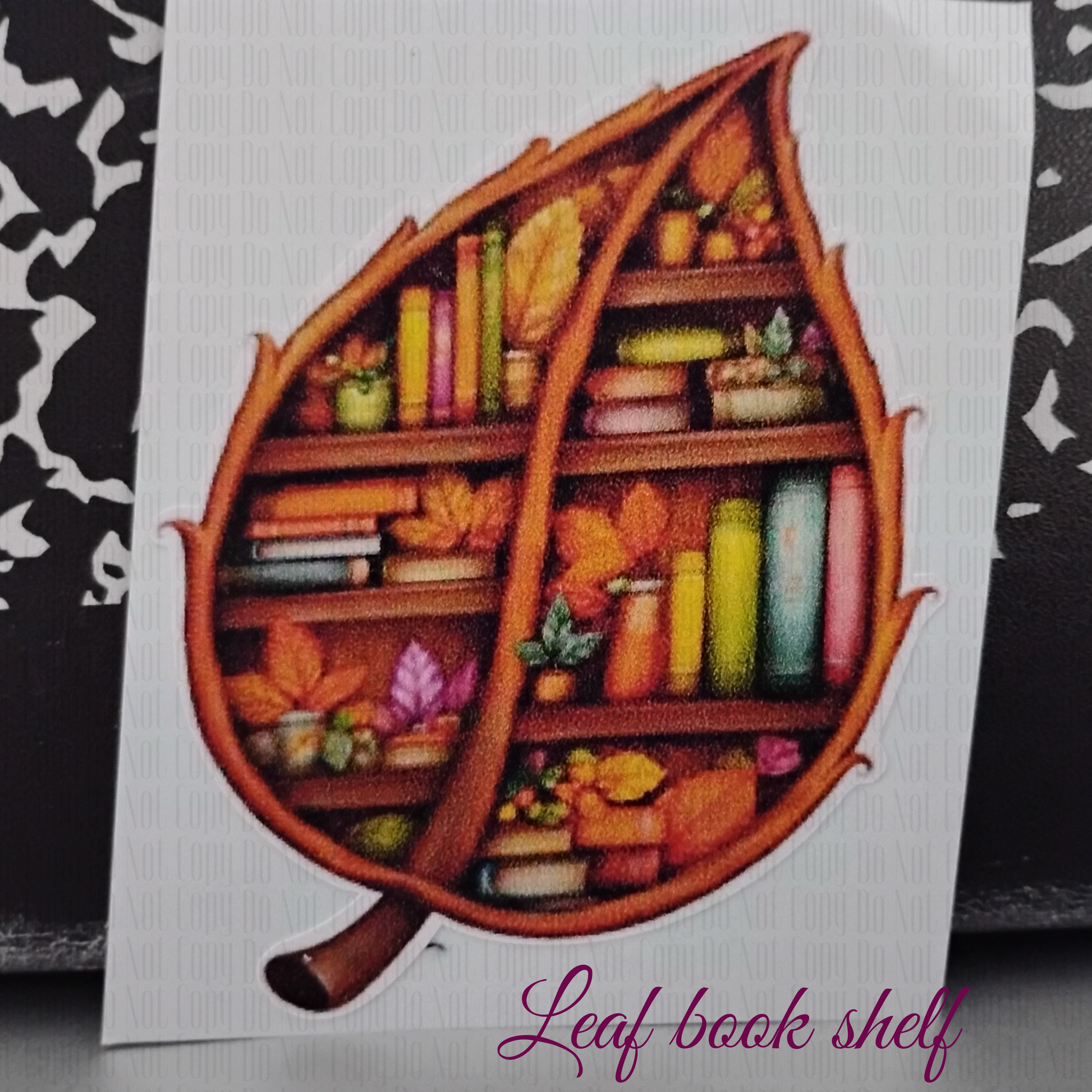 Sticker of a bookshelf shaped like a leaf filled with colorful books