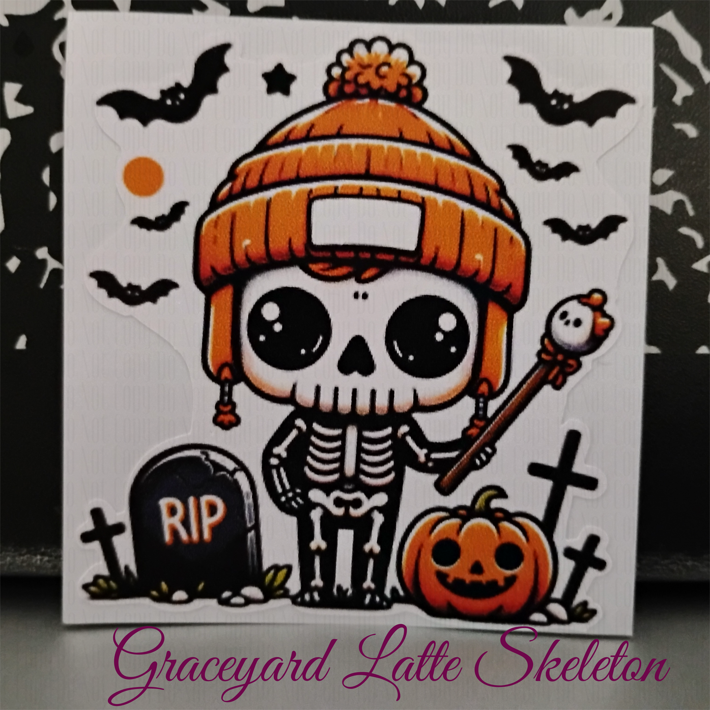 skeleton in orange beanie with gravestone, pumpkin